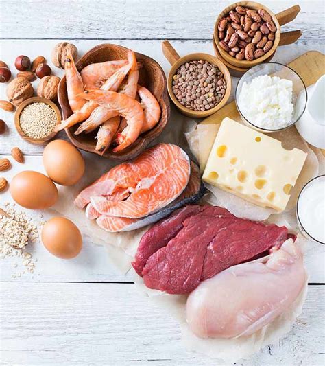 an assortment of meats, eggs, nuts and milk on a white wooden table