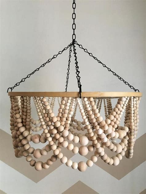 a chandelier made out of wooden beads hanging from a chain on a wall