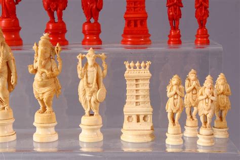 AN EARLY 20TH CENTURY IVORY AND STAINED IVORY INDIAN CHESS SET, carved as Indian gods and temples, l