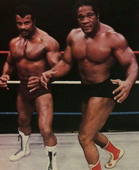 two muscular men standing next to each other