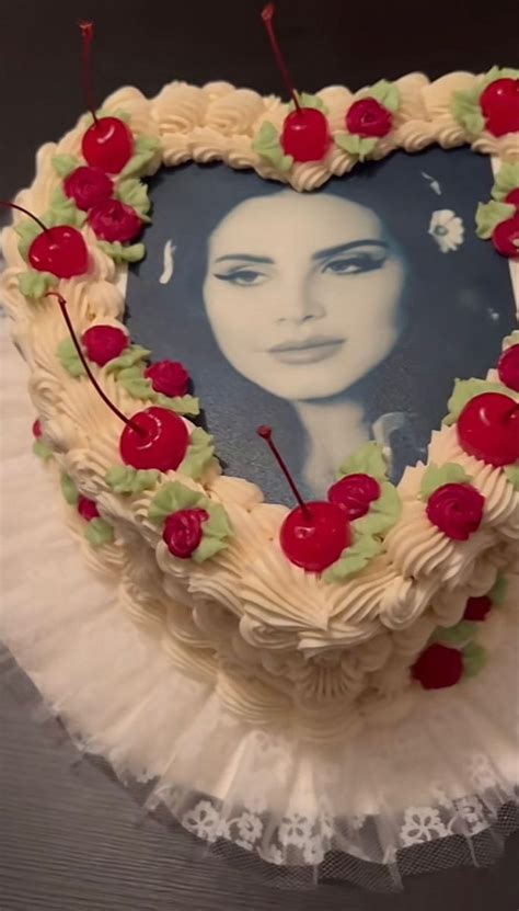 a heart shaped cake decorated with cherries and an image of a woman's face