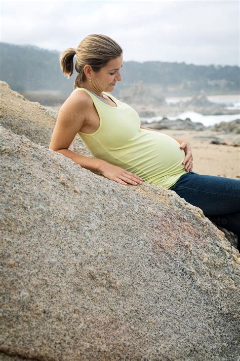 Smiling Pregnant Woman on a Beach Stock Photo - PixelTote