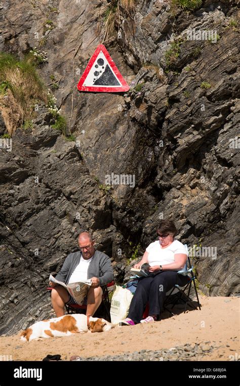 UK, Wales, Ceredigion, Llangrannog, amusing signs, couple sat at base ...