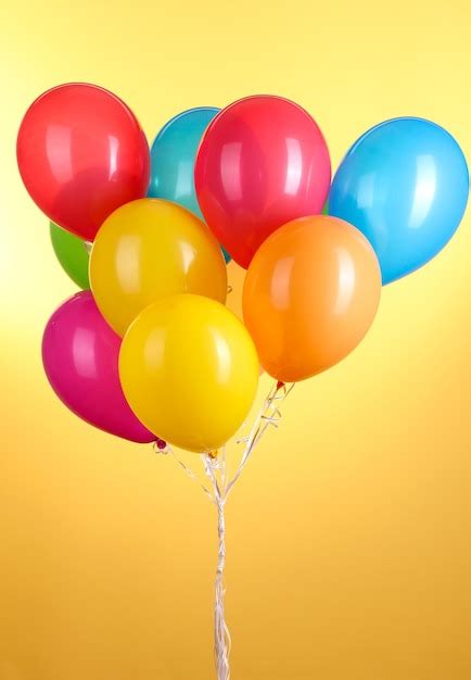 Premium Photo | Colorful balloons on yellow background