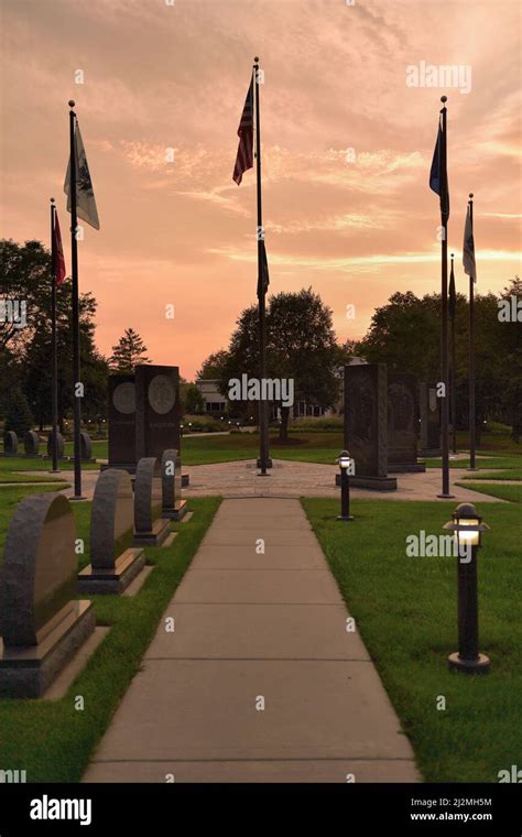 Streamwood, Illinois, USA. The setting sun beyond a veterans memorial ...