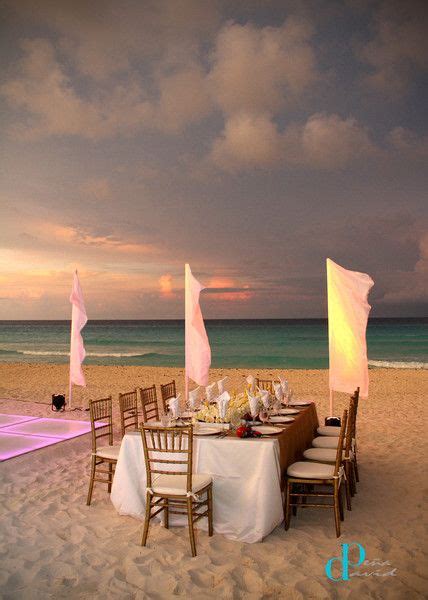 a table set up on the beach at sunset