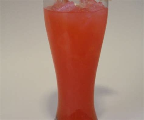 a tall glass filled with pink liquid and topped with an orange flower on the stem