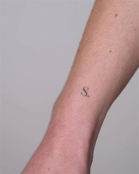 Minimalistic style letter "S" tattoo located on the
