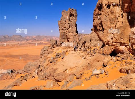 people hiking   sandstone rock formation tadrart tassili najjer