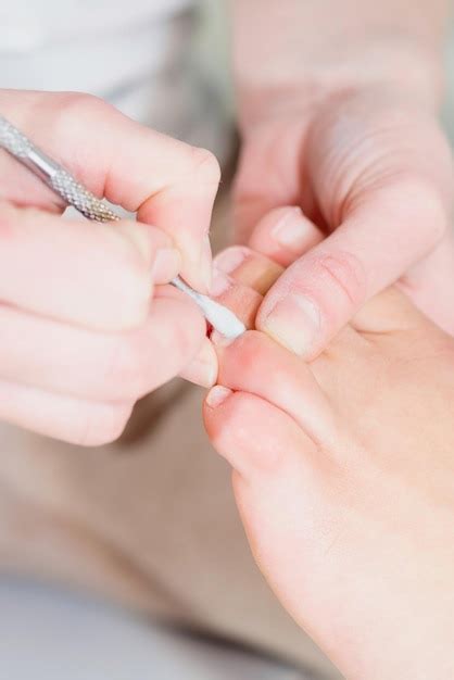 Premium Photo | Cleaning cuticles at pedicure salon