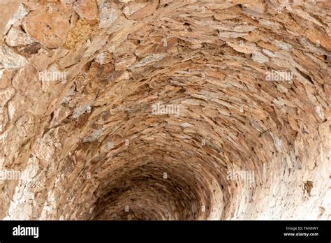 Tunnel made of stone with natural light coming in Stock Photo - Alamy