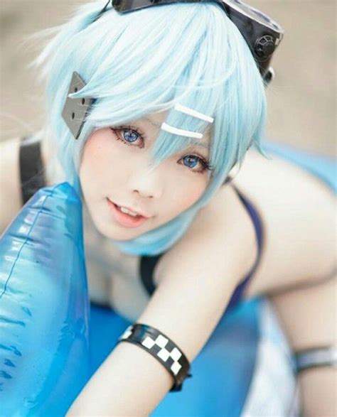 a woman with blue hair and goggles on her head sitting in an inflatable