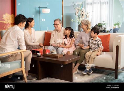 Happy family talking in living room Stock Photo - Alamy