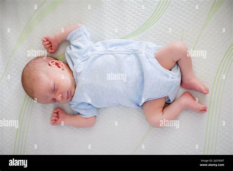 Cute little peaceful baby calm sleeps soundly in his crib in a bright ...