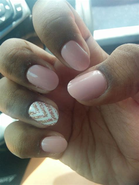 Cute baby pink nails, with a white base and gold Chevron design on the