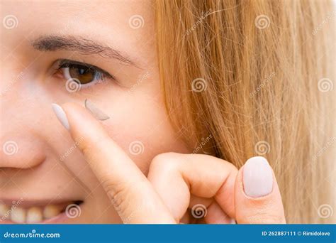 side view   smiling woman applying contact eye lenses stock image