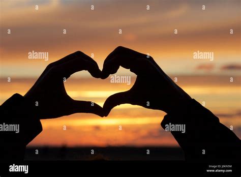 Hands forming the shape of a heart at sunset Stock Photo - Alamy