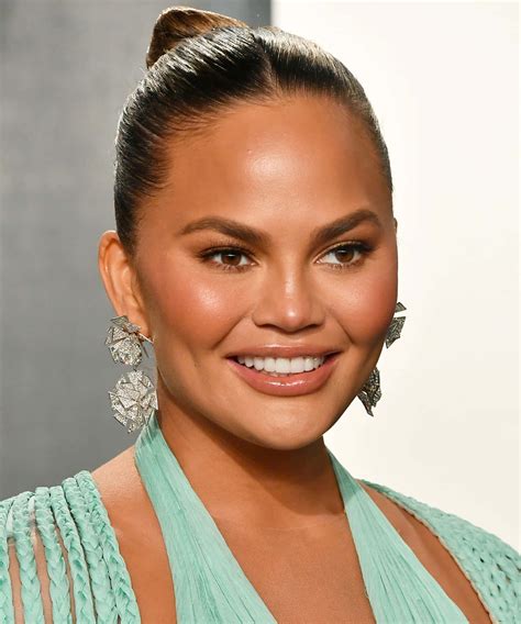 Download Chrissy Teigen Smiling Portraitwith Earrings Wallpaper