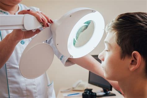 Premium Photo | Concentrated dermatologist using medical loupe in the ...