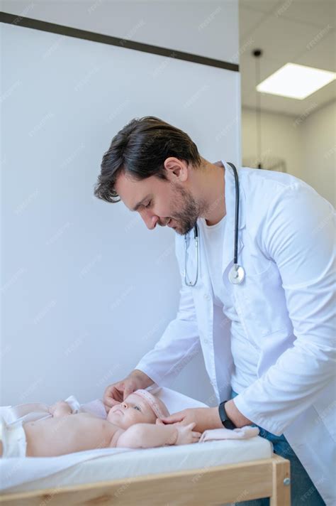 premium photo babys examining male pediatrician examining  baby