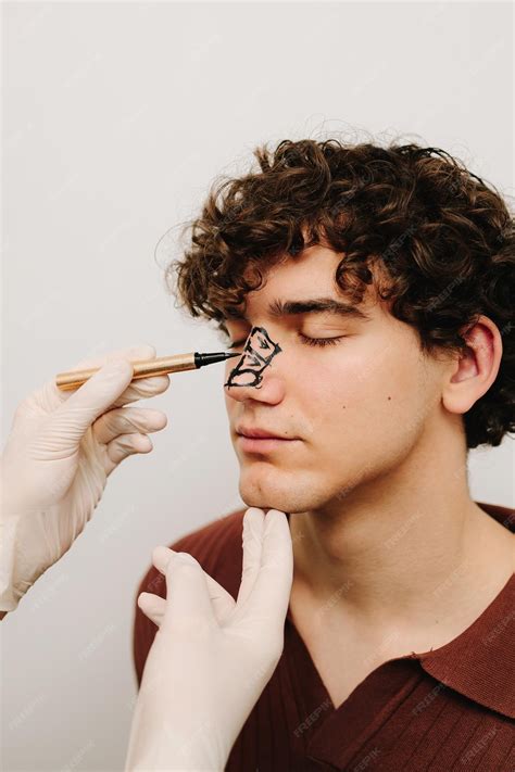 Proceso de dibujo de marcaje en la nariz masculina antes de la cirugía