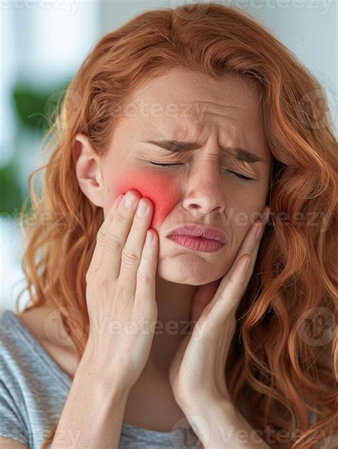 A woman holds her cheek while suffering from a toothache, depicting the