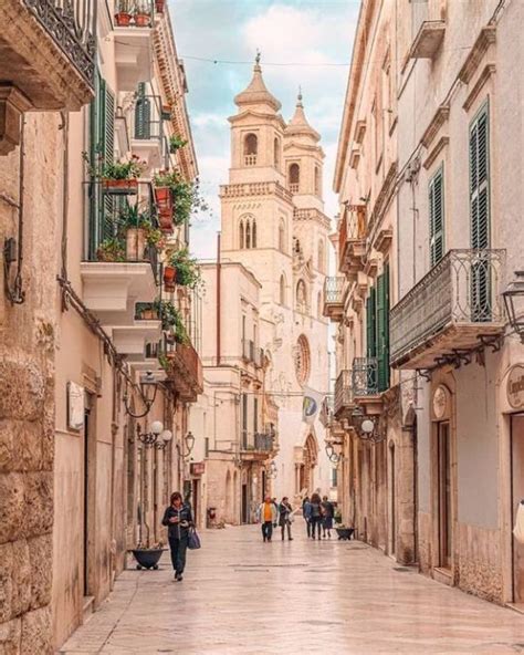 people are walking down an alley way in the old part of town with stone ...