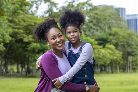 African American mother is hugging her young daughter while having a