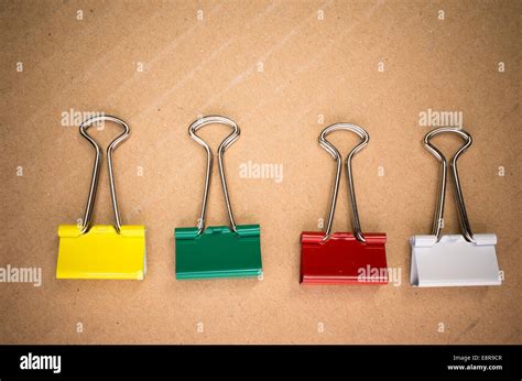 colored metal paper clips on a cardboard background Stock Photo - Alamy