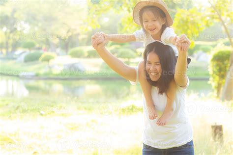 Beautiful young asian mother carrying little daughter with smile, child