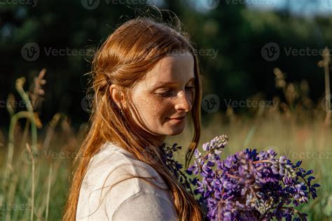 Close up portrait of young beautiful redhead woman with freckles