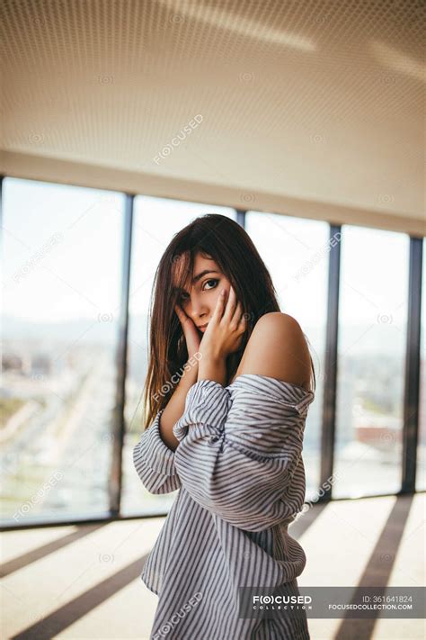 Back view of dreamy sensual beautiful woman in striped shirt showing