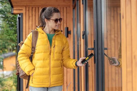 Young Female in Yellow Down Jacket Unlocks Door Smart House Stock Photo ...