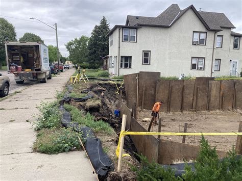 The hole next door. Is it construction code compliant? Unlit. Unfenced