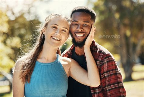 Portrait of interracial couple, young people and relax in park