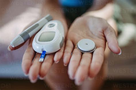 Nahaufnahme von Händen, die Diabetes-Zubehör und -Geräte halten ...