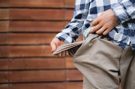 man showing  empty pockets poor