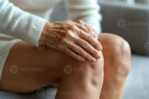 Senior woman experiencing knee pain while sitting on sofa 59581816