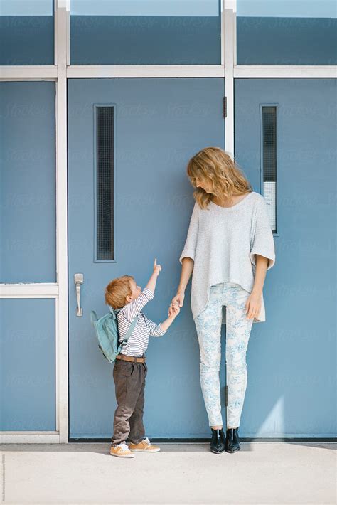 "Mother And Son Holding Hands In Front Of A School" by Stocksy