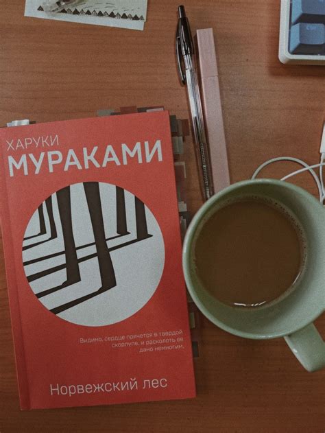 a cup of coffee next to a book on a table
