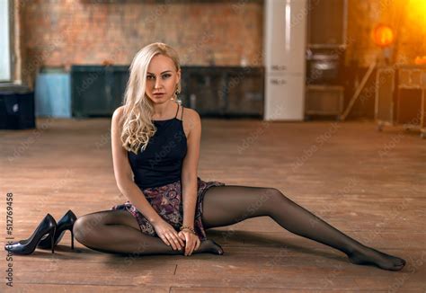Beautiful woman with perfect legs plays on the kitchen floor in black ...