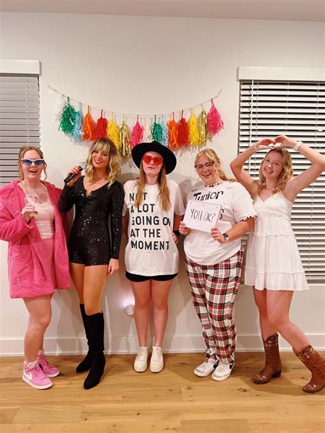 four women posing in front of a wall