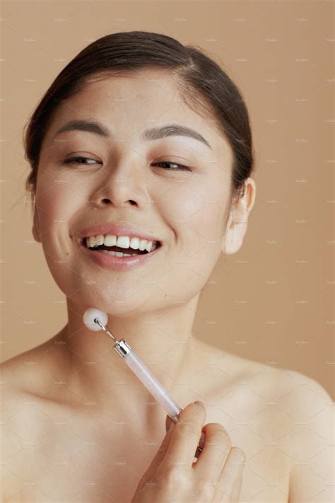 modern asian woman with roller massager | People Images ~ Creative Market