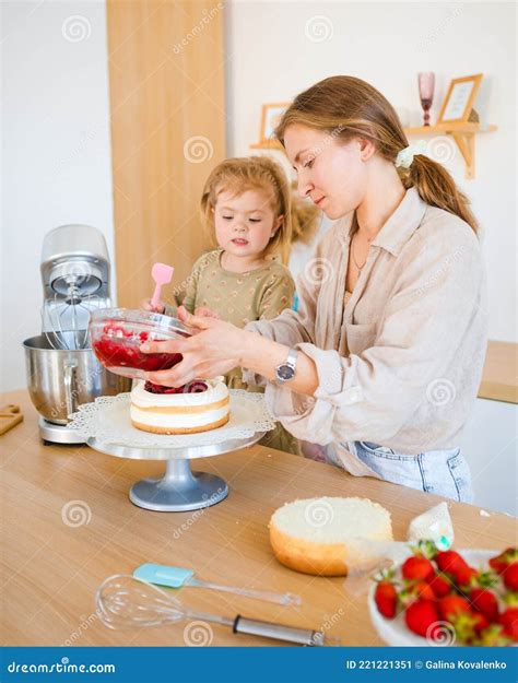 Mom and Daughter are Baking a Beautiful Dessert with Cream. Stock Image