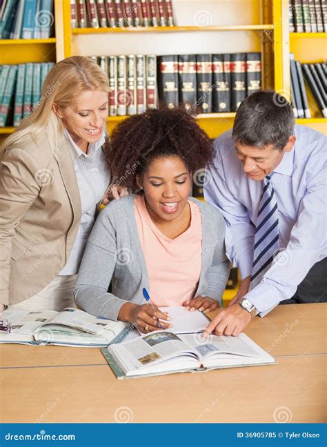 Teachers Assisting Student in College Library Stock Image - Image of