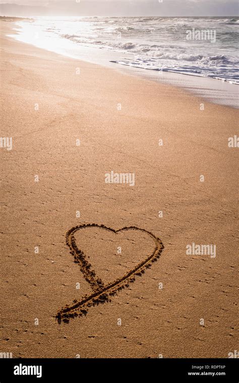 heart drawn   sand   beach  sunset  waves washing  stock photo alamy