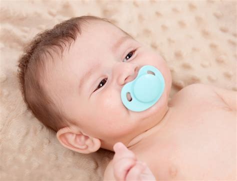 premium photo cute baby smiling  blue pacifier