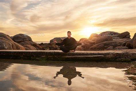 Sunset, yoga or zen man in meditation by a calm or peaceful lake or ...