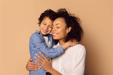 Como Criança Em Seus Braços - Mulher afro-americana segurando uma criança em seus braços mostrando ...