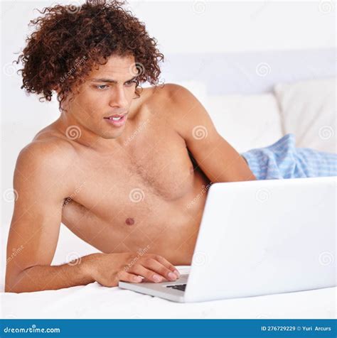 Never Too Early To Get Connected. a Young Man Propped Up in Bed Using a
